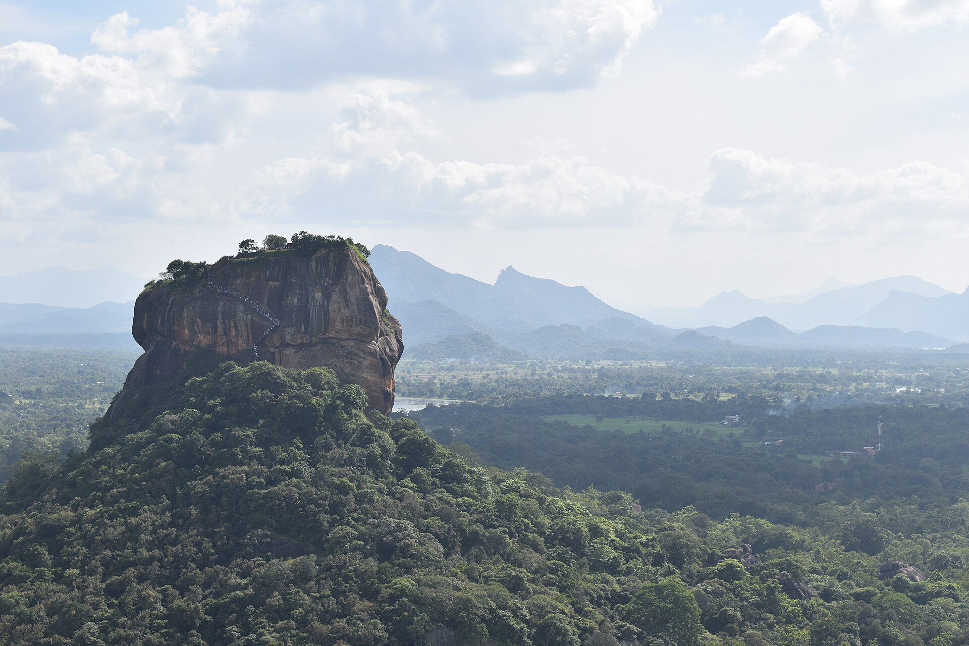 Sigiriya rock fortress seen from Pidurangala, the ascent staircase visible on its face