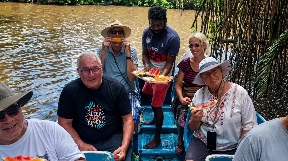 A Mathew Tours guide serving fresh fruit to guests aboard a river boat