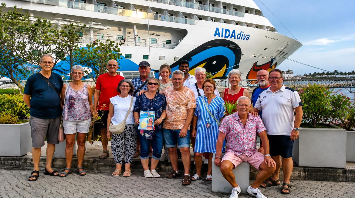 A large group of Mathew Tours guests photographed beside a cruise ship in port